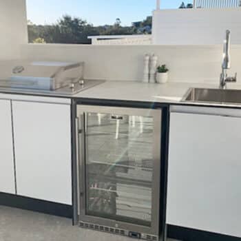 White Outdoor Kitchen with White Cement Benchtop, Hood Cooktop and Outdoor Fridge