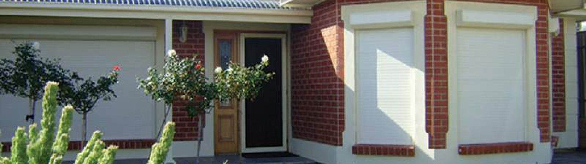 Cream Roller Shutters Closed on Brick Home