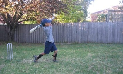 child playing backyard cricket